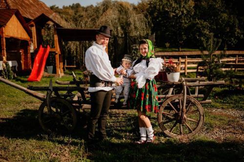 a man and a woman and a child standing next to a cart at Casa Pintea de Sub Coastă in Breb
