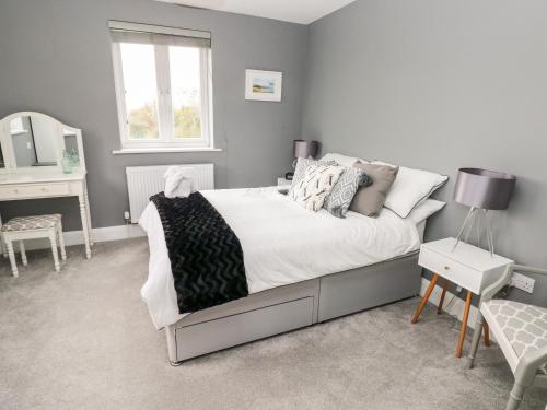 a bedroom with a bed and a table and a mirror at 9 Pilgrims Way in Roch