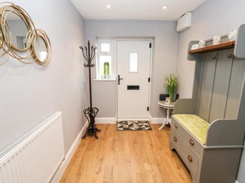 a hallway with a door and a table and a mirror at 9 Pilgrims Way in Roch