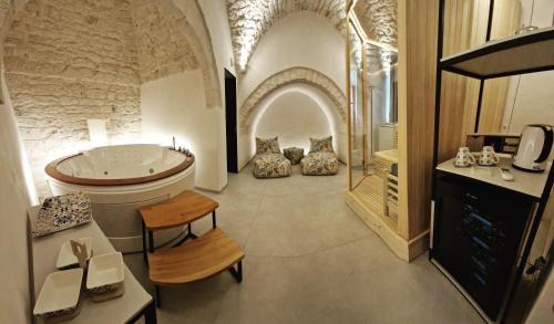 PIRANO Suite e Spa في سيغلي ميسابيكا: حمام كبير مع حوض ومغسلة