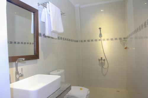 a bathroom with a toilet and a sink and a shower at D'Camel Hotel Lembongan in Nusa Lembongan