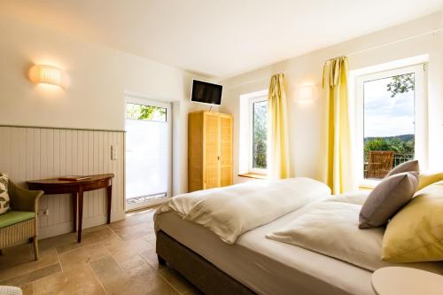a bedroom with a large bed and two windows at Hohenlohe Hideaway in Langenburg