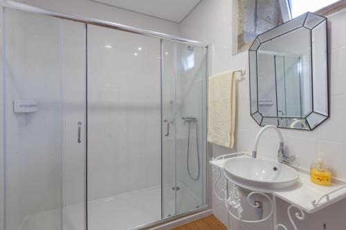baño blanco con ducha y lavamanos en Casa dos Arcos, en Caminha