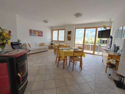 ein Wohnzimmer mit einem Sofa, einem Tisch und Stühlen in der Unterkunft Bed & Breakfast Valtellina in Castione Andevenno