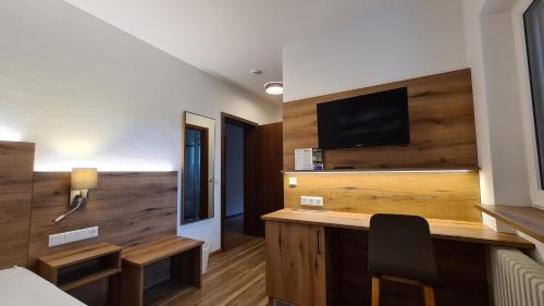 a hotel room with a desk with a tv on a wall at Gästehaus Funk in Bad Feilnbach