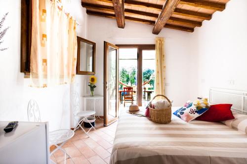a bedroom with a bed in a room with a patio at Agriturismo Fontetrilla in Orbetello