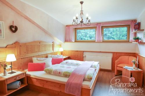 a bedroom with a bed and two windows at Panorama Appartement in Ramsau am Dachstein