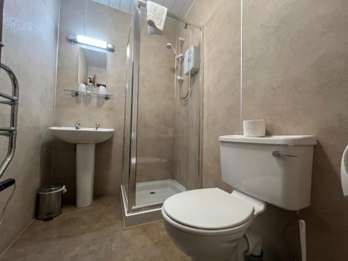 a bathroom with a toilet and a shower and a sink at Smithton Hotel in Inverness