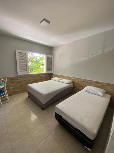 - une chambre avec deux lits, une chaise et une fenêtre dans l'établissement Pousada Durma Bem, à Tianguá