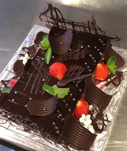 a chocolate cake with strawberries on top of it at All Seasons Residence Design Hotel - Free parking in Sofia