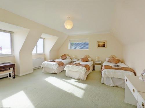 um quarto no sótão com 3 camas e um piano em 11 Shorecroft, Aldwick em Bognor Regis