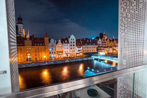 a view of a city at night from a balcony at CLASSY APARTMENTS - Gdańsk - Widok z Wyspy in Gdańsk