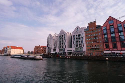 a group of buildings next to a body of water at CLASSY APARTMENTS - Gdańsk - Widok z Wyspy in Gdańsk