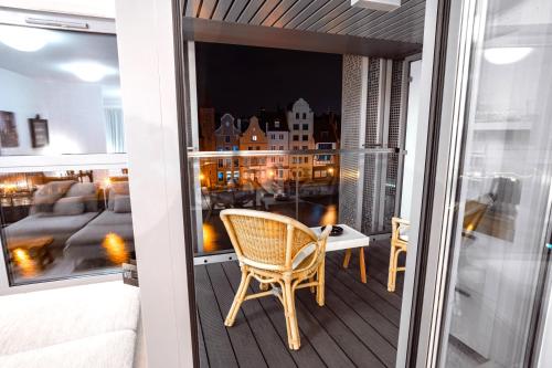 a balcony with a chair and a room with a view at CLASSY APARTMENTS - Gdańsk - Widok z Wyspy in Gdańsk
