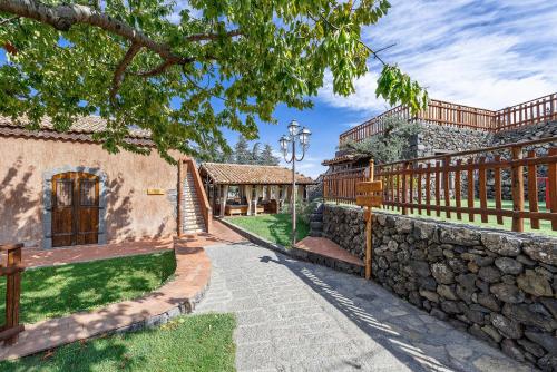 a fence and a stone wall next to a building at Etna Quota Mille Boutique Hotel, Typical Sicilian Food & Wine in Randazzo