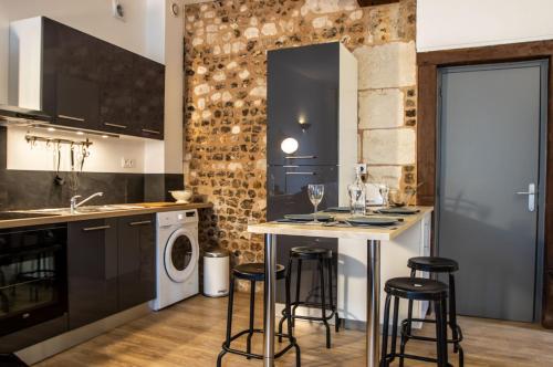eine Küche mit einer Waschmaschine, einem Trockner und einem Tisch in der Unterkunft Appartement Cosy Au Sein De La Venise Normande in Pont-Audemer
