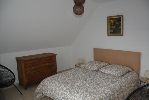 een slaapkamer met een bed en een houten dressoir bij Appartement Leonard de Vinci in Montlouis-sur-Loire