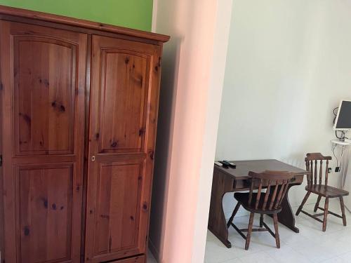 une armoire en bois à côté d'une table et de chaises en bois dans l'établissement Charme, à Solèminis