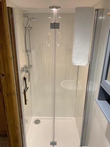 a shower with a glass door in a bathroom at Whistley View in Brackley