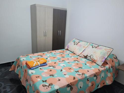 a bedroom with a bed with a comforter and a pillow at Comodo y bonito apartamento en Palmira Las Americas in Palmira