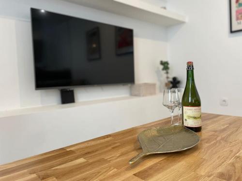 une bouteille de vin et un verre sur une table dans l'établissement Le logis BAYA - WEEKEND & HOLIDAY - WIFI & TV, à Saint-Vigor-le-Grand