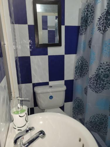 y baño con aseo blanco y lavamanos. en Comodo y bonito apartamento en Palmira Las Americas, en Palmira