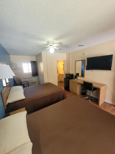a hotel room with two beds and a desk at Economy Inn Sylva in Sylva