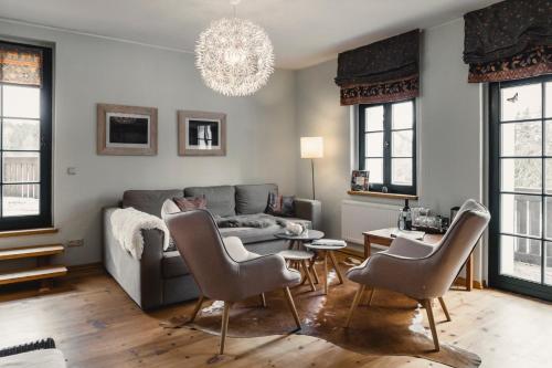 a living room with a couch and a table and chairs at Altsächsischer Gasthof Kleines Vorwerk in Sayda