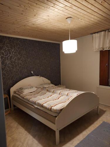 a bed in a bedroom with a wooden ceiling at Kivirannantie 28 in Iisalmi