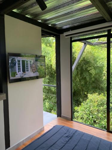 a living room with a tv on the wall next to a window at Entre Bambus 1 in Pereira