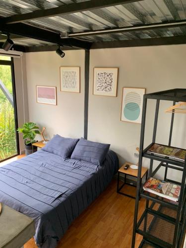 a bedroom with a blue bed and a ladder at Entre Bambus 1 in Pereira