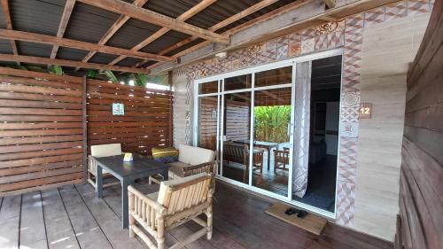 a screened in porch with a table and chairs at Tropicana Beach & Resort in Elwa