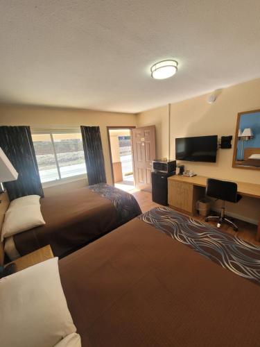 a hotel room with two beds and a desk at Economy Inn Sylva in Sylva