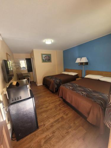 a hotel room with two beds and a television at Economy Inn Sylva in Sylva
