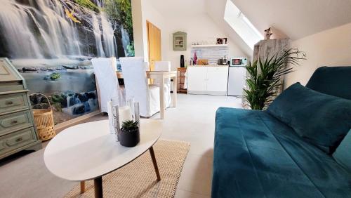 a living room with a blue couch and a table at Wohnung zwischen Nord- und Ostsee mit Fitnessraum in Ostenfeld