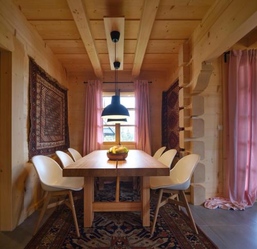 a dining room with a wooden table and chairs at Willa Pawliki in Rzepiska
