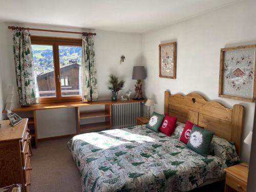 a bedroom with a bed with red pillows and a window at Appartement La Clusaz, 3 pièces, 6 personnes - FR-1-459-43 in La Clusaz