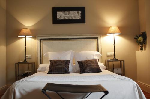 a bedroom with a large white bed with two lamps at Narbasu Restaurante y Hotel in Cereceda