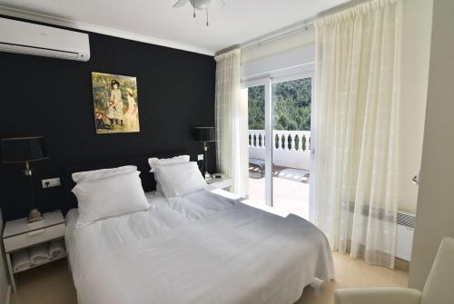 a bedroom with a white bed and a window at Dream Villa in Benidoleig