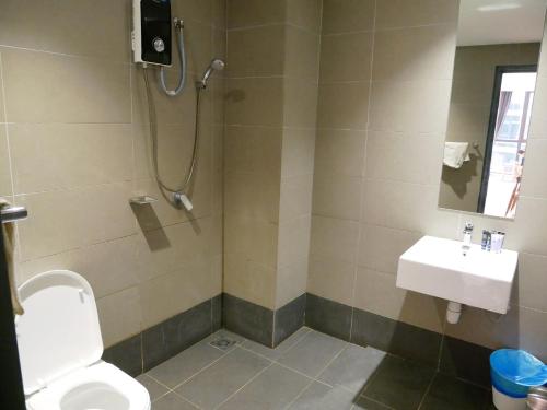 a bathroom with a shower and a toilet and a sink at Atria Sofo Suites - Petaling Jaya in Petaling Jaya