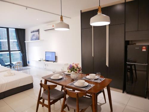 a kitchen and living room with a table and chairs at Atria Sofo Suites - Petaling Jaya in Petaling Jaya