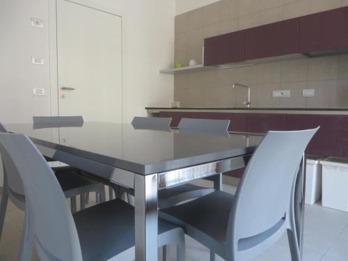a kitchen with a dining table and chairs at Komodo short stay apartments in Trento