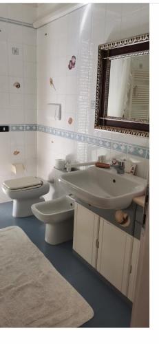een badkamer met 2 toiletten, een wastafel en een spiegel bij Charlotte room in Bassano del Grappa