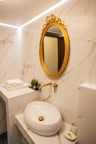 a white bathroom with a sink and a mirror at Vip Lepanto Castle Suites in Nafpaktos