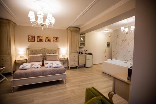 a bedroom with a bed and a tub and a sink at Vip Lepanto Castle Suites in Nafpaktos