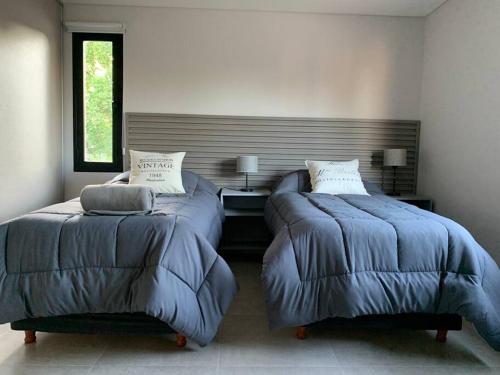 dos camas sentadas una al lado de la otra en un dormitorio en Duplex Lujan Mendoza cercanía Chacras de Coria en Luján de Cuyo