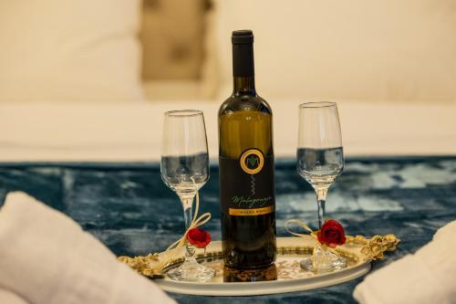a bottle of wine and two glasses on a table at Vip Lepanto Port Suites in Nafpaktos