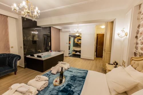 a bathroom with a tub and a bed and a room at Vip Lepanto Port Suites in Nafpaktos