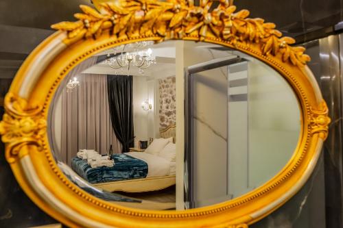 a gold mirror with a bed in a bedroom at Vip Lepanto Port Suites in Nafpaktos