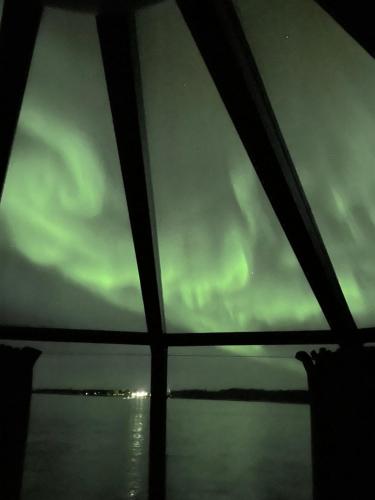 an view of the northern lights through a window at Ylläsjärvi iglu in Ylläsjärvi